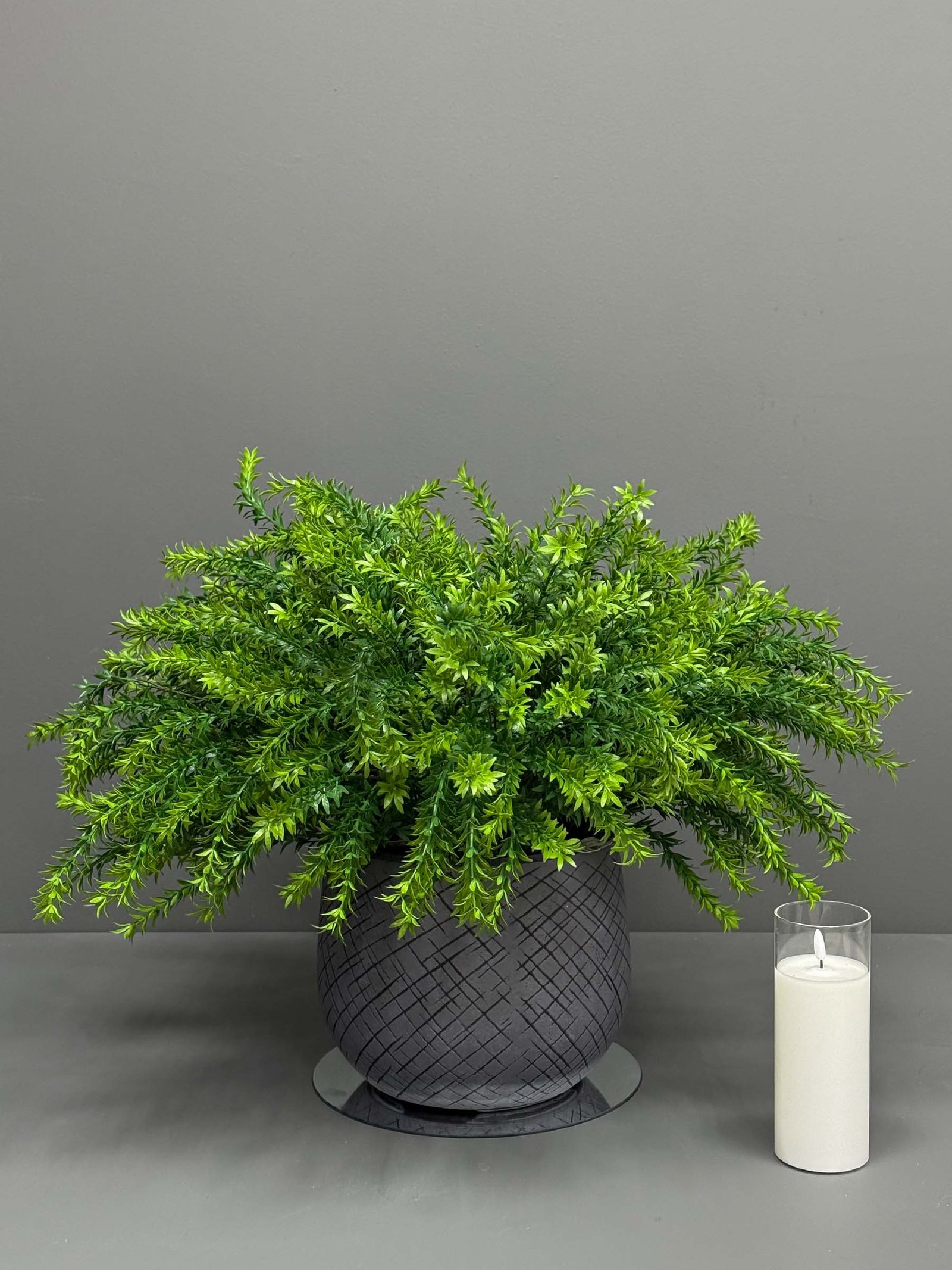 Transform your space with our Artificial Greenery Arrangement in Textured Grey Pot, featuring vibrant and lively shades of green. Enhance your decor today!
